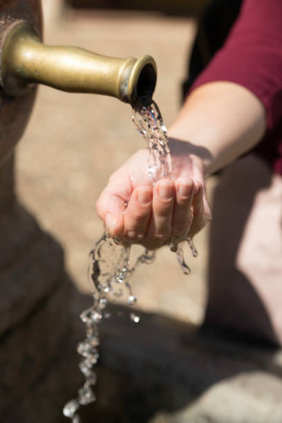 istock Woman's hands getting wet in a fountain to cool off 1342624800