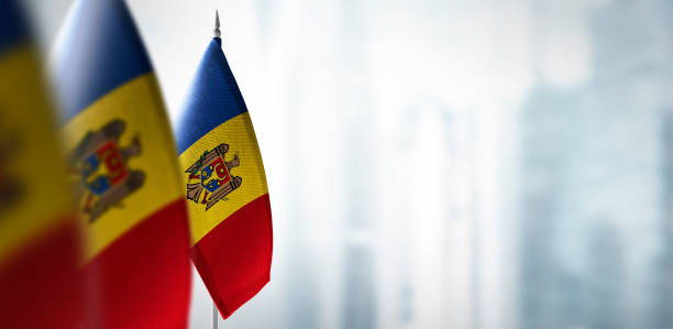 Small flags of Moldavia on a blurry background of the city stock photo