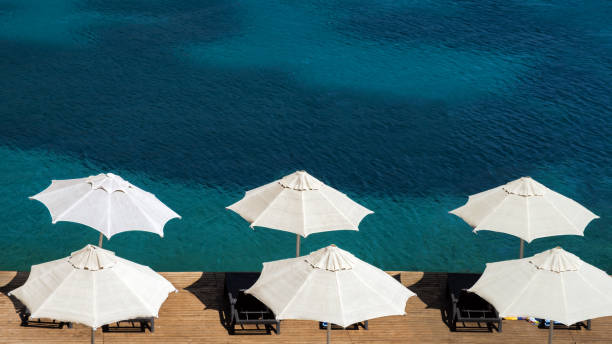 istock Sun umbrellas on wooden pier 1342626112