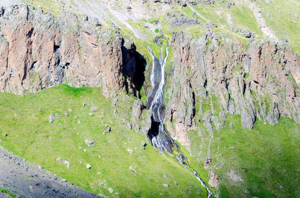 waterfall in the Caucasus mountains among the stones filmed from a height stock photo
