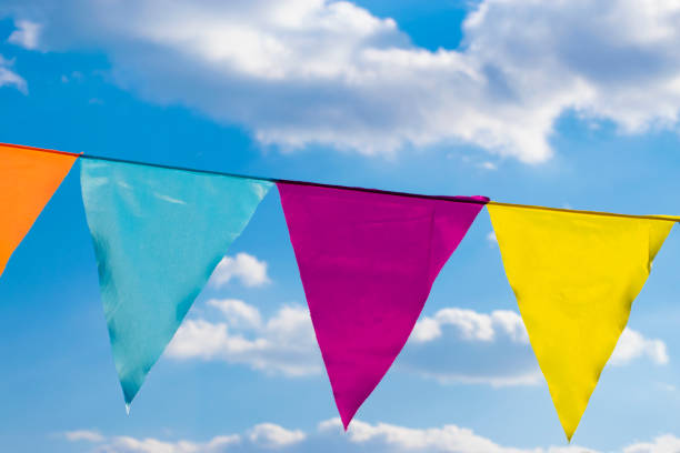 Colorful triangle flags diagonal with the blue sky.