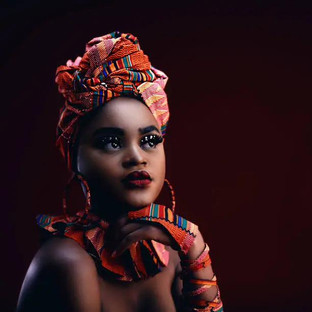 dark portrait of beautiful african woman in traditional nigerian costume