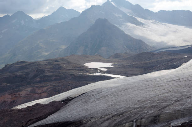 stones and snow on the mountainside in early autumn stock photo