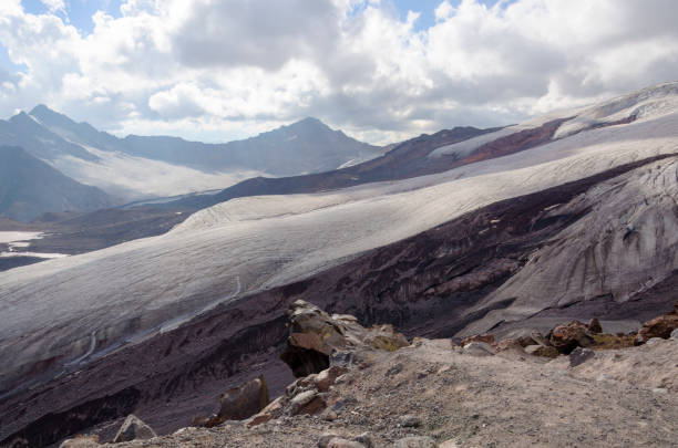 stones and snow on the mountainside in early autumn stock photo