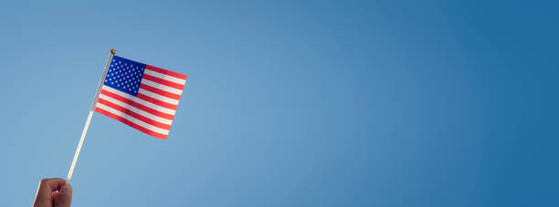 istock Waving an American flag over blue sky background 1342631311
