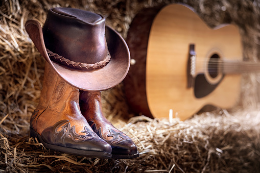 Guitarra de sombrero de vaquero y botas en granero, concierto en vivo del festival de música country o fondo de rodeo photo