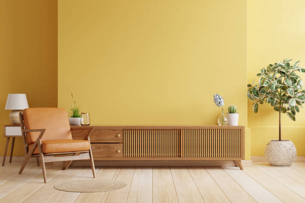 gabinete tv en sala de estar moderna con sillón de cuero y planta sobre fondo de pared amarillo. - furniture contemporary domestic room sparse fotografías e imágenes de stock