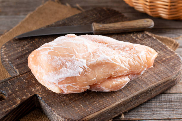 테이블에 도마에 냉동 닭 필렛. 냉동 식품 - chicken raw chicken breast meat 뉴스 사진 이미지