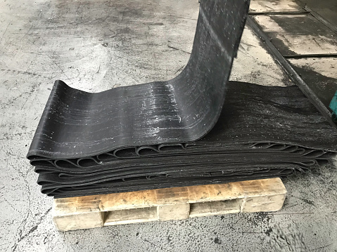 Natural rubber raw material is kept in the production area of the rubber factorysliced rubber plates stacked on palletsNatural rubber raw material is kept in the production area of the rubber factorysliced rubber plates stacked on pallets