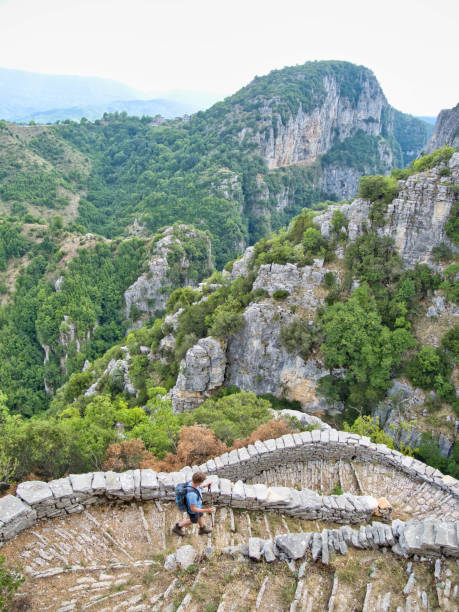 A young man descends the Vradeto Steps in the Zagori village Vradeto which is in the area of the Vikos Gorge Vradeto is one of the Zagori villages (s.a. Monodendri, Papigko), Vikos Gorge, Epirus) zagori stock pictures, royalty-free photos & images