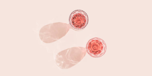 Two glasses of rose sparkling wine top view, fashion glass with beautiful pattern with dark shadows on pastel pink background. Two glasses of rose sparkling wine top view, fashion glass with beautiful pattern with dark shadows on pastel pink background. rosé wine stock pictures, royalty-free photos & images