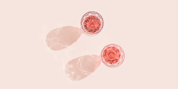 two glasses of rose sparkling wine top view, fashion glass with beautiful pattern with dark shadows on pastel pink background. - nobody alcohol champagne wine imagens e fotografias de stock