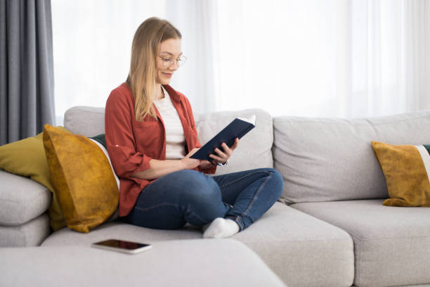 istock Young woman reading a book at home. 1342689627