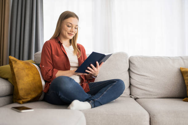 istock Young woman reading a book at home. 1342689647