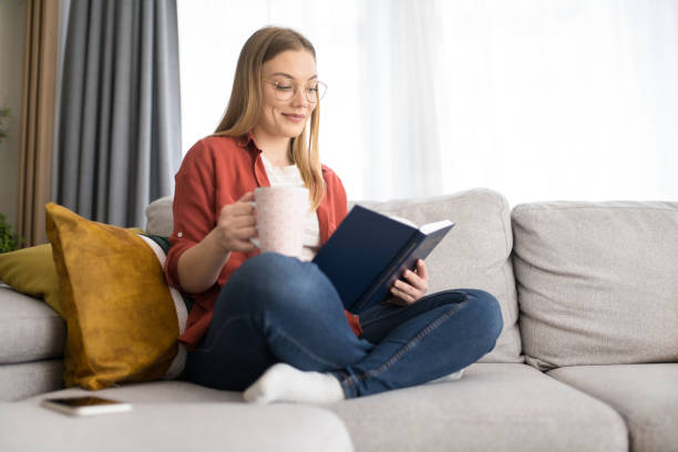 istock Young woman reading a book at home. 1342690168