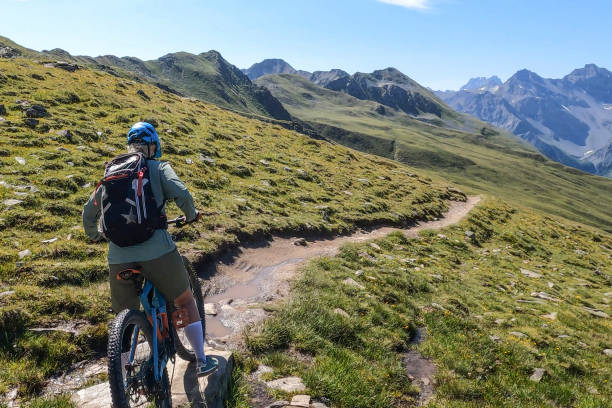 istock Woman mountain bikes along sunny bike path 1342698943
