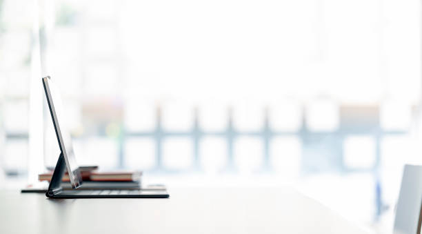 istock Tablet with magic keyboard on the table in bright room in panoramic view. 1342703773