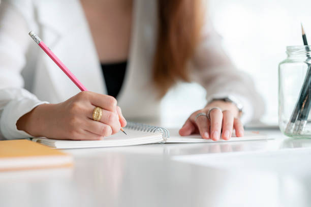 istock Closeup of woman's hand writing on notebook. 1342703822