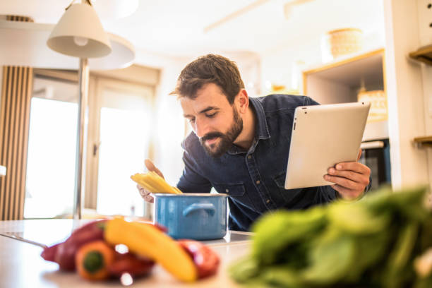 istock Young man enjoys cooking at home. 1342706984