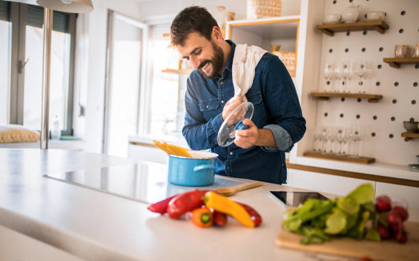 istock Happy young man preparing food in the kitchen. 1342708360