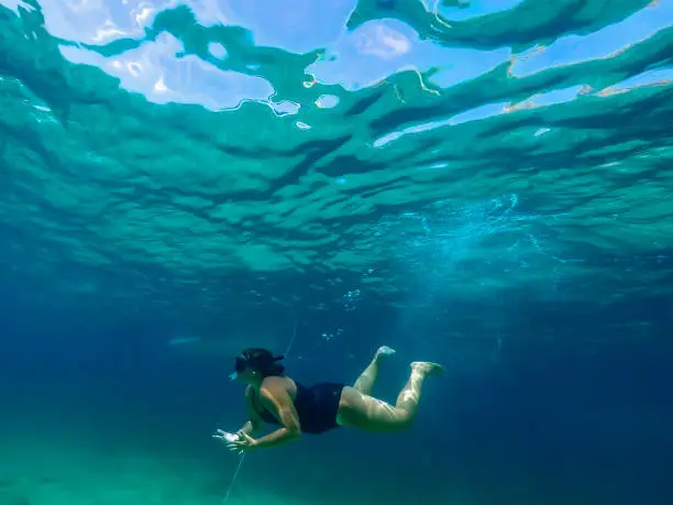 Woman diving with goggles and tube in the turquoise waters of Formentera.  watersports