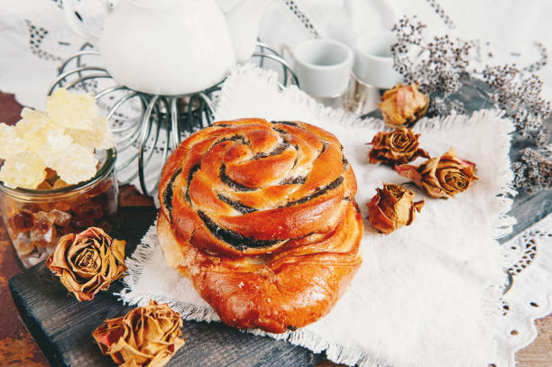 Puff pastry, sliced poppy seed roll, sweet poppy seed bun on a white plate. A traditional sweet poppy seed bun is served with coffee for Breakfast
