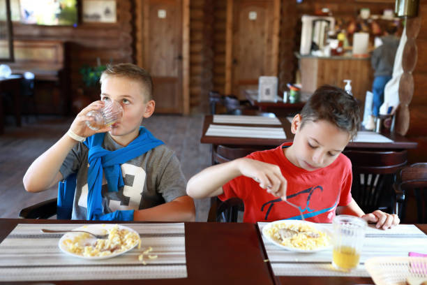 istock Two children eating pasta 1342713944