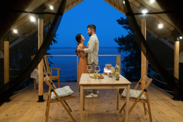 istock Young couple standing in embrace between served table and seaside 1342714814