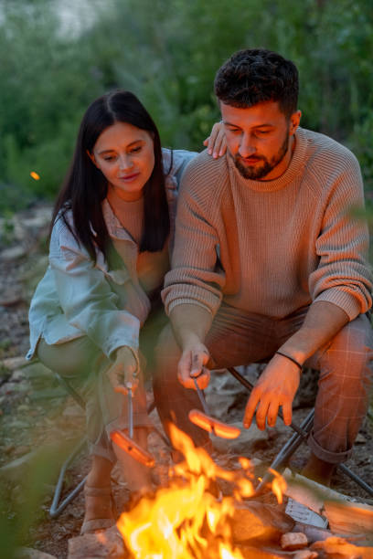istock Young affectionate couple frying sausages over fire 1342714821