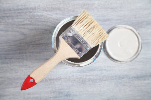 istock White paint and brush on white wooden background. 1342716377