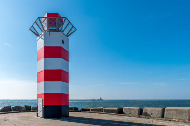 red and white lighthouse on the north pier of ijmuiden - ijmuiden imagens e fotografias de stock