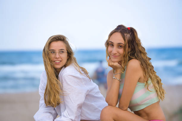 istock Charming girlfriends on sandy beach in evening 1342738939