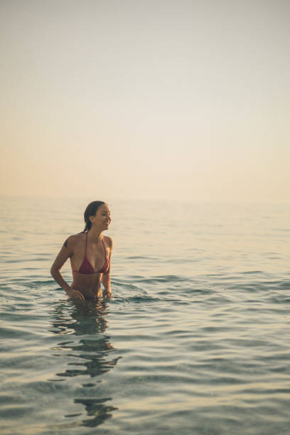istock Young woman walks through Mediterranean Sea 1342748651