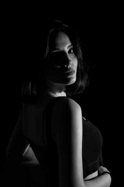 Portrait of attractive a young woman with cinematic lighting. Woman wearing a suspender bodysuit. Half naked sexy woman. stock photo
