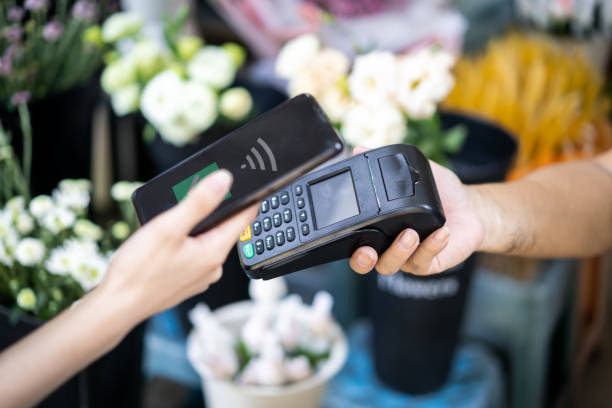 istock A female customer uses her mobile phone to make a payment in a store 1342769064