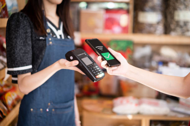 istock A female customer uses her mobile phone to make a payment in a store 1342769069