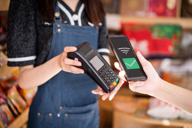 istock A female customer uses her mobile phone to make a payment in a store 1342769080