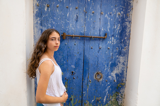 Ibiza Eivissa young girl on blue grunge door in Dalt vila downtown