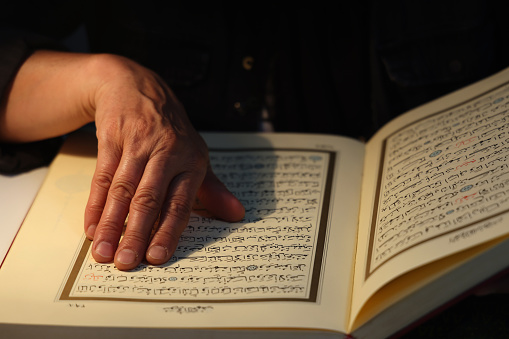 Senior muslim woman reading Quran at home