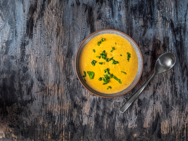 istock Puree soup with basil herbs in deep gray plate 1342779003
