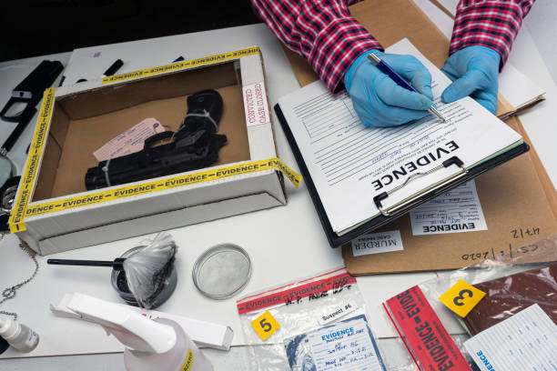 istock Close up of forensic science evidence box containing gun from crime scene, conceptual image 1342783254