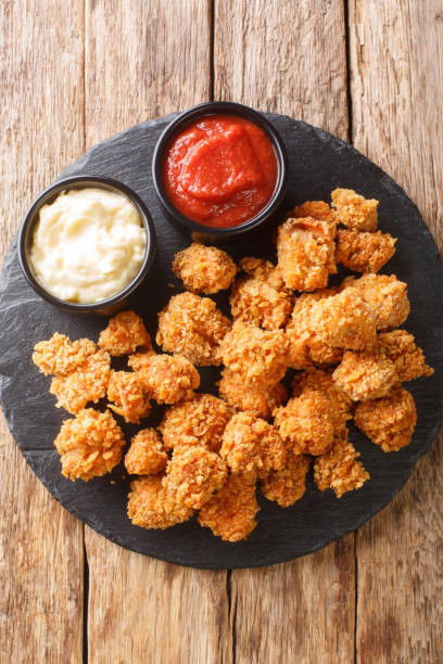 istock American Chicken popcorn with two sauces close-up on a slate board. vertical top view 1342784170