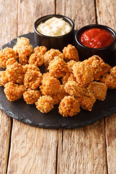 istock American Chicken popcorn with two sauces close-up on a slate board. vertical 1342784254
