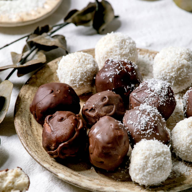 istock Raw vegan coconut chocolate candy balls over white with eucalyptus branches 1342784777