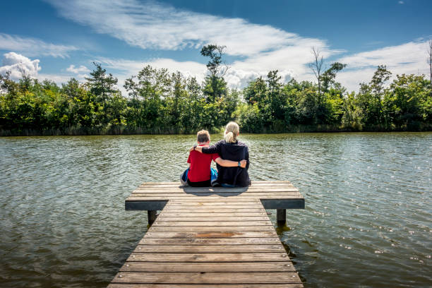 istock mother and son sitting on wooden pier 1342806764