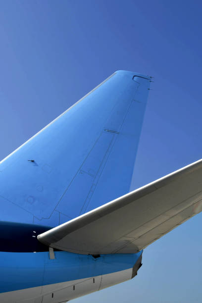 Tail fin of a modern jet against a deep blue sky
