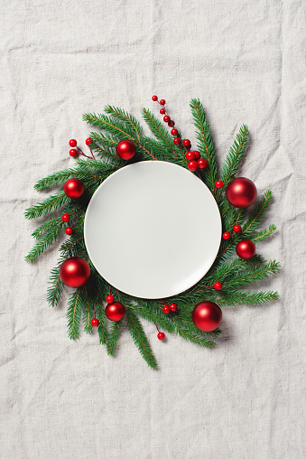 Festive Christmas table setting, holiday decoration with fir branches and red balls