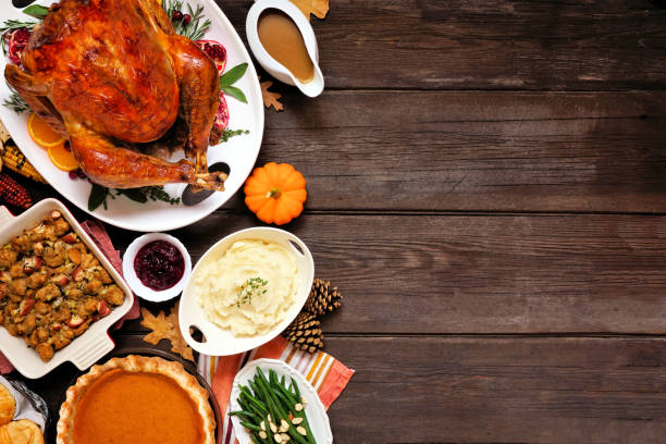 Classic Thanksgiving turkey dinner. Top down view side border on a dark wood background with copy space. Classic Thanksgiving turkey dinner. Top down view side border on a dark wood background with copy space. Turkey, mashed potatoes, stuffing, pumpkin pie and sides. turkey meat stock pictures, royalty-free photos & images