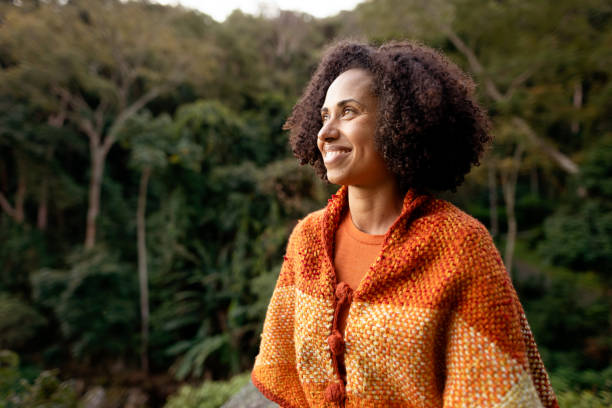 istock Smiling woman in a warm jacket looking at a scenic forest view 1342820040