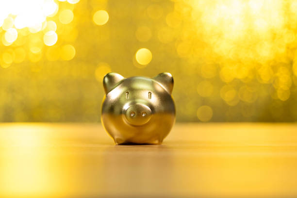 piggy bank on shiny golden background - pension retirement benefits perks imagens e fotografias de stock